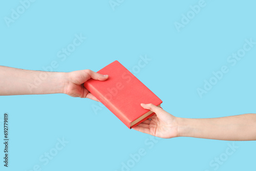 Εκτύπωση καμβά Hand passing book to another person on pink background