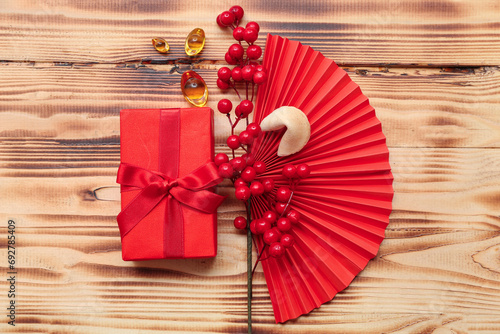 Photos Gift box with fortune cookie and Chinese symbols on wooden background