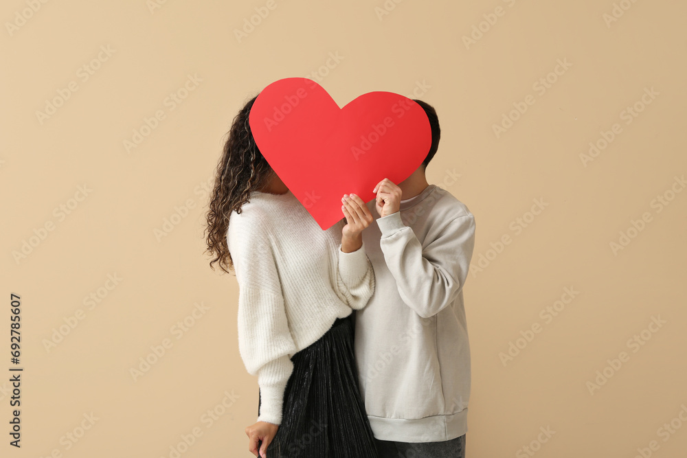 Couple with red heart for Valentine's day on beige background Couple with red heart for Valentine's day on beige background