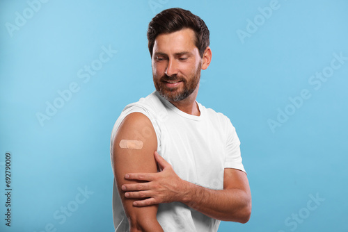 Εκτύπωση καμβά Man with sticking plaster on arm after vaccination against light blue background