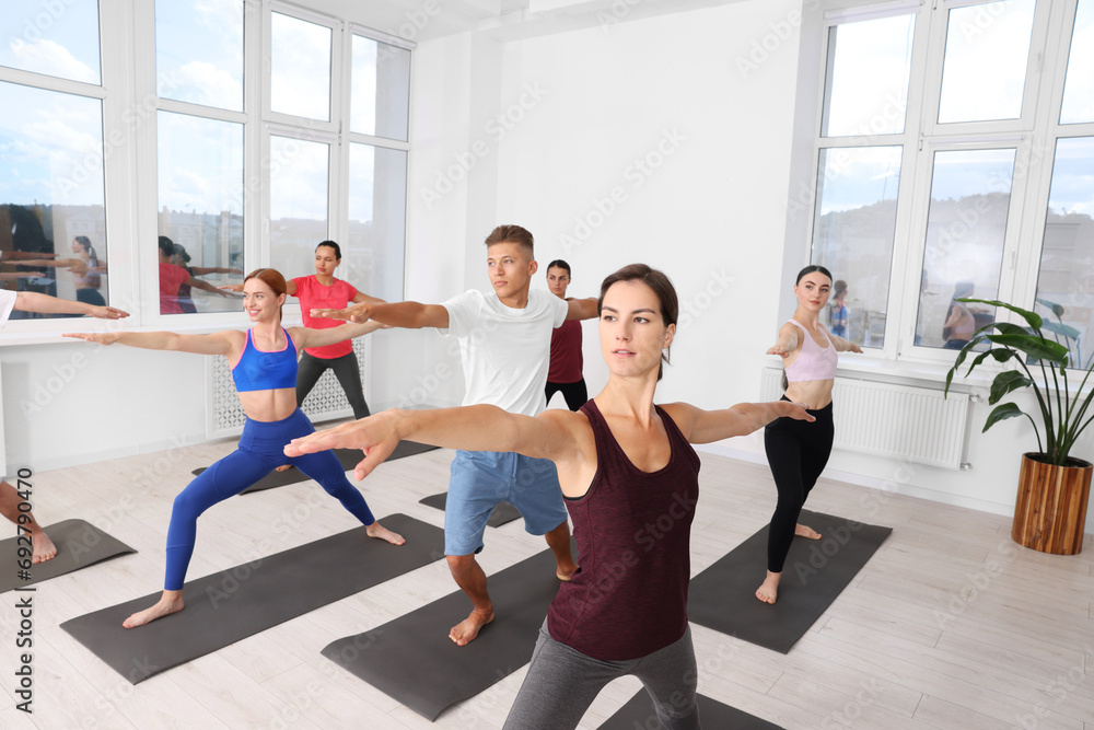 Obraz premium Group of people practicing yoga on mats indoors
