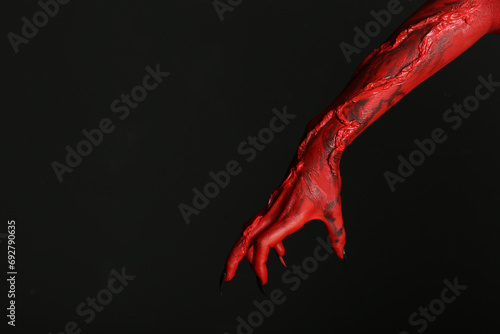 Scary monster on black background, closeup of hand with space for text. Halloween character