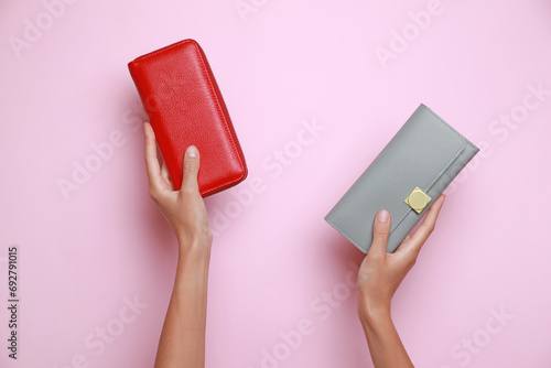 Woman holding leather purses on pink background, closeup photo