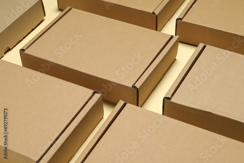 Many closed cardboard boxes on pale yellow background  closeup