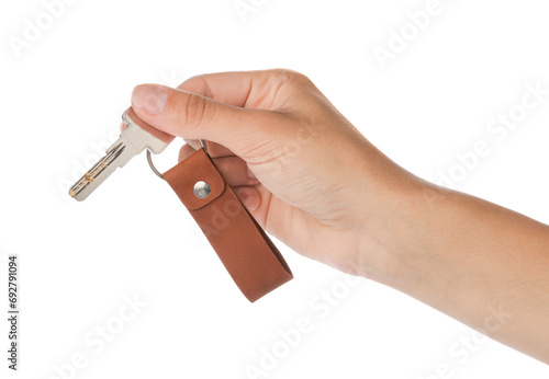 Woman holding key with leather keychain on white background, closeup