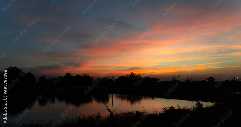 Twilight in the Evening with Orange Gold Sunset, Real amazing panoramic sunrise or sunset sky with gentle colorful clouds. Nature background, Sky background.