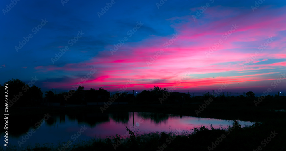 Naklejka premium Twilight in the Evening with Orange Gold Sunset, Real amazing panoramic sunrise or sunset sky with gentle colorful clouds. Nature background, Sky background.
