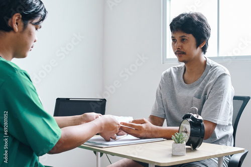Asian male patient receiving a prescription medicine from doctor in the clinic photo