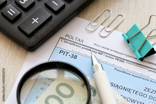 Declaration of the amount of earned income or incurred loss, PIT-38 tax forms on accountant table with pen and polish zloty money bills close up photo