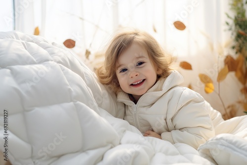 Cute and Happy child looking out of the white blanket. Copy space.