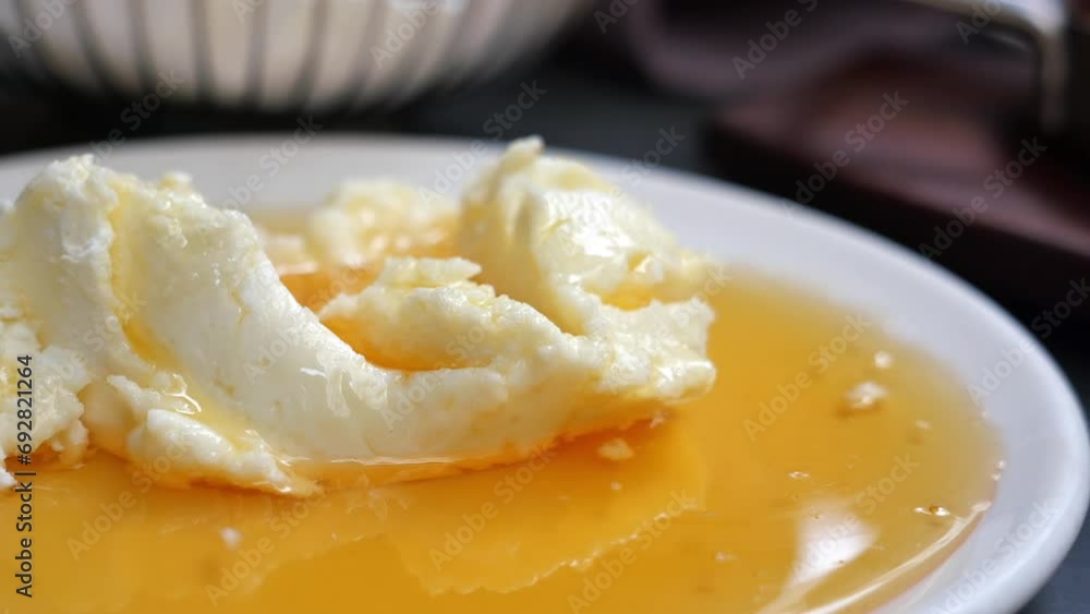 butter cream and honey in a bowl on table . butter cream and honey in a bowl on table .