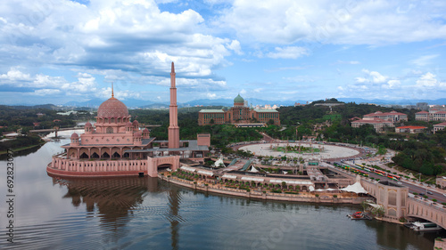 A stunning view of the Putra Mosque in Malaysia. The mosque is a large, pink building with a large dome and four minarets. It is located on an artificial island and lake in Putrajaya.