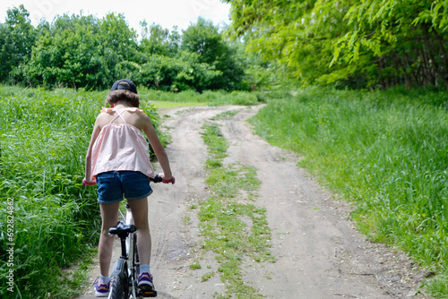 Young girl cyclist enjoy the beautiful sunrise on summer forest trail