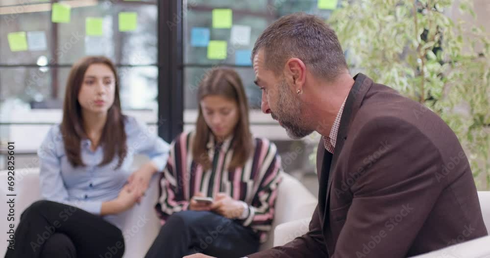 Young female colleagues discussing work related problems with senior supervisor. Start up business team having a brainstorming meeting at modern office space. Young female colleagues discussing work related problems with senior supervisor. Start up business team having a brainstorming meeting at modern office space.