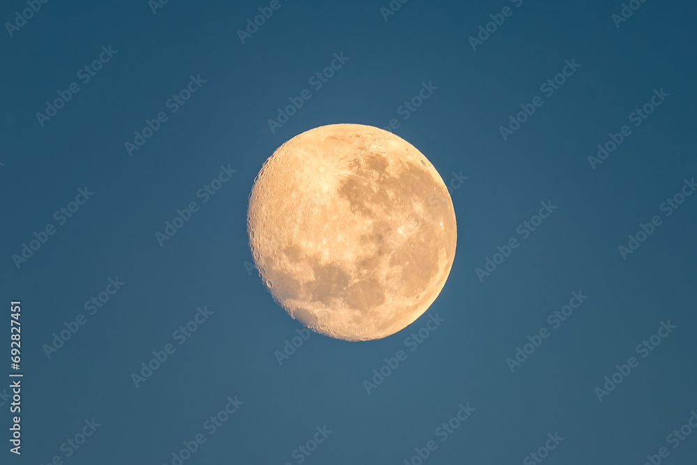 Early morning setting 92% partial moon in the blue sunrise sky Early morning setting 92% partial moon in the blue sunrise sky