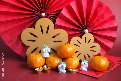 Chinese New Year of the dragon festival concept. Mandarin orange, red envelopes, dragon and gold ingot with red paper fans. Chinese character 