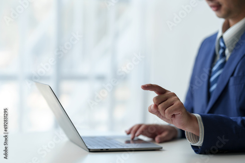 businessman working on laptop computer Print email check work Send information online on white desk Finger pointing at business goals planning success in office.
