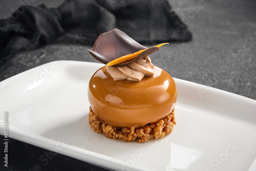 Fotografija Sophisticated hazelnut praline mousse cake with a smooth glaze and chocolate dec
