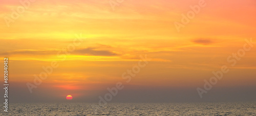 Enjoy a panoramic view of the skyline. The sun rises in the morning sky with colorful clouds. and beautiful cloud patterns In the soft light of the morning at sea