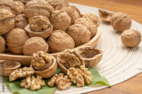 Walnuts in wooden tral on wooden background, Walnuts kernels on wooden table. photo