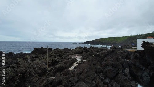 Woman standing in a rocky volcanic landscape in Varadouro, Azores photo