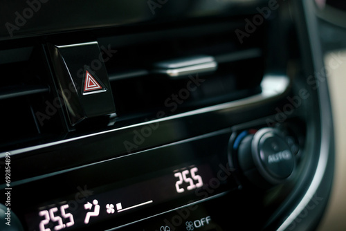 close-up of car dashboard, hazard flasher switch or emergency light button in modern car, shallow depth of field photo
