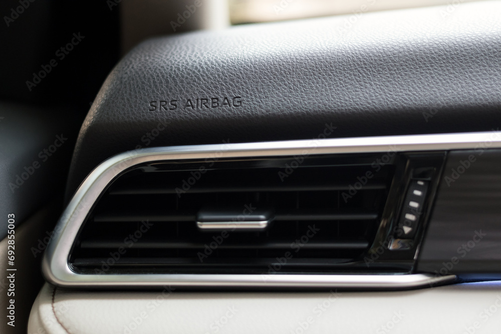 engraved SRS airbag sign on car dashboard, air vent grill outlet in modern car, shallow depth of field engraved SRS airbag sign on car dashboard, air vent grill outlet in modern car, shallow depth of field