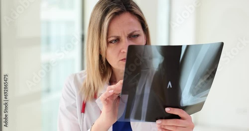 Traumatologist radiologist analyzes x-ray of patient ulnar bones photo
