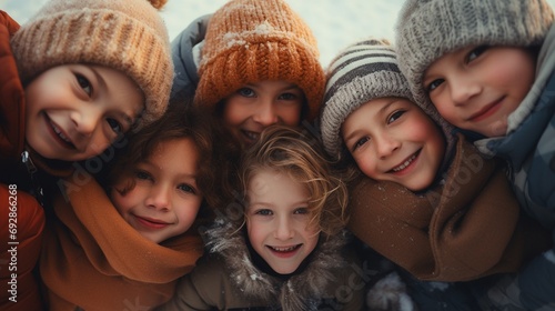 Group of kids wrapped up in warm clothes hugging together and have fun outdoor on snowy background, group of happy winter children playing together. photo