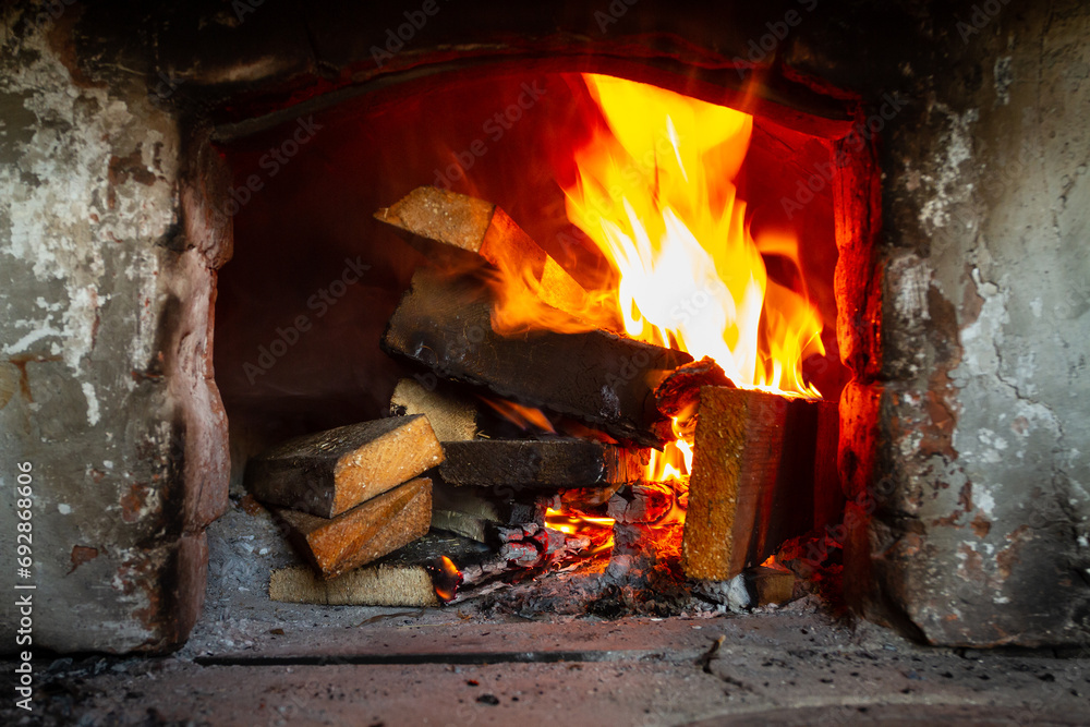 A stack of wooden planks is burning in the old hearth A stack of wooden planks is burning in the old hearth