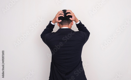 Back view of businessman grabbing his head showing stress gesture
