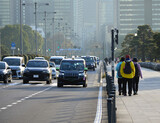 冬の東京都の都心の道路と車と歩く観光客の姿