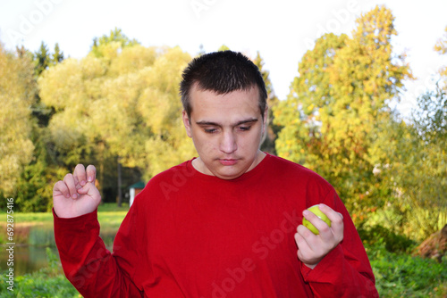 Autistic adult guy walking with apple in hand