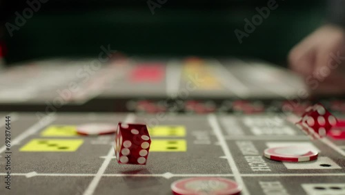 Closeup slow motion footage of a croupier hand throwing dices on dealing craps table in a casino photo