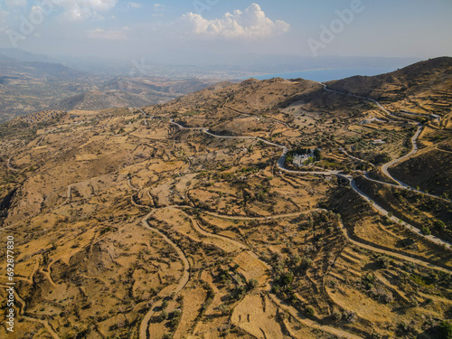 Aerial landscape of hills in Crete, Greece, Rethymno area with winding roads and olive trees
