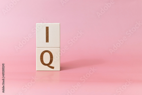 Text IQ on wooden cubes on a pink background, copy space. Coefficient intellect concept
