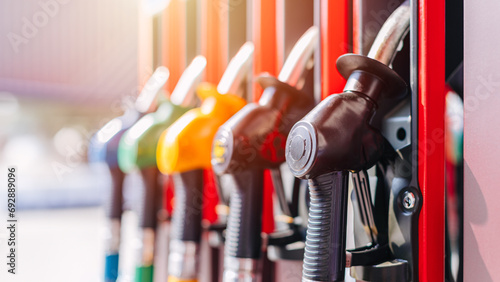 Diesel petrol fuel pistols nozzle refill at gas station. Fuel price crisis impact fuel cost in transport business and Travel energy consumption rise in petroleum gasoline station service production. photo