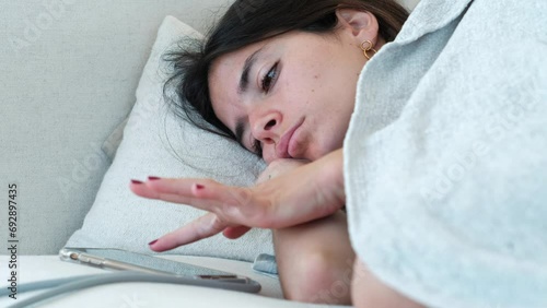 Morning Routine: Woman Snoozing Alarm While Waking Up photo