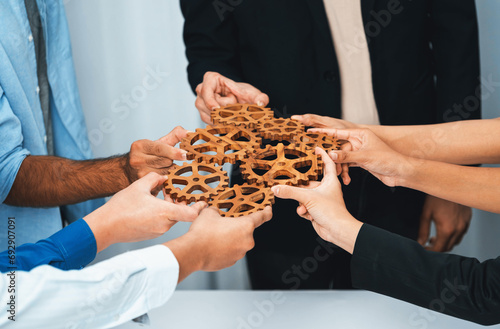 Business team joining cogwheel in circular together symbolize successful group of business partnership and strong collective unity teamwork in community workplace with productive efficiency. Prudent