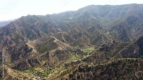 Farm in the middle of a green valley with small water reservoir