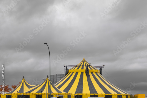 Bright yellow exterior of a circus and a cloudy gray sky photo