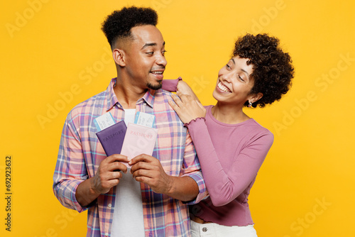 Traveler couple two friends family man woman wearing casual clothes hold passport ticket isolated on plain yellow background. Tourist travel abroad in free time rest getaway. Air flight trip concept. #692923632