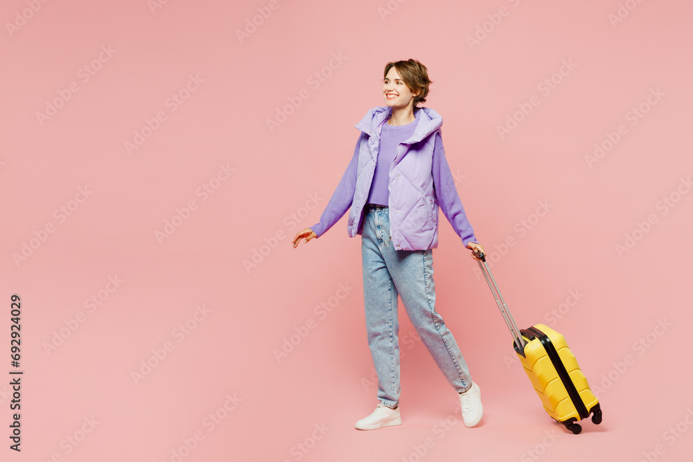 Sideways traveler woman wears vest casual clothes hold bag stroll go isolated on plain pastel pink background. Tourist travel abroad in free spare time rest getaway. Air flight trip journey concept. Sideways traveler woman wears vest casual clothes hold bag stroll go isolated on plain pastel pink background. Tourist travel abroad in free spare time rest getaway. Air flight trip journey concept.
