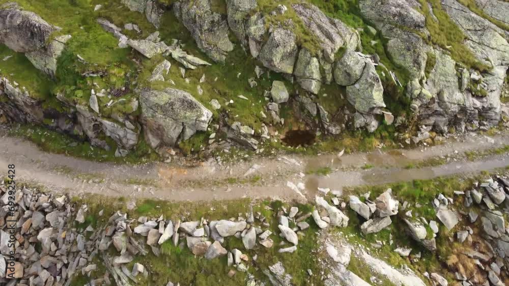 Drone shot of a stone field tilting up to reveal a house surrounded by a stone field and a few snow fields in the Alps in Kaernten, Austria Drone shot of a stone field tilting up to reveal a house surrounded by a stone field and a few snow fields in the Alps in Kaernten, Austria