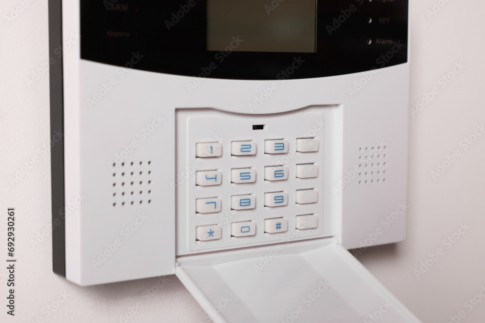 Home security alarm system on white wall, closeup Home security alarm system on white wall, closeup
