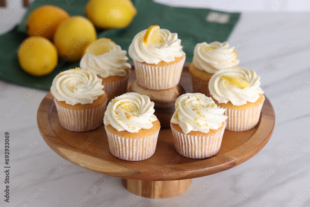 Delicious lemon cupcakes with white cream on table, closeup