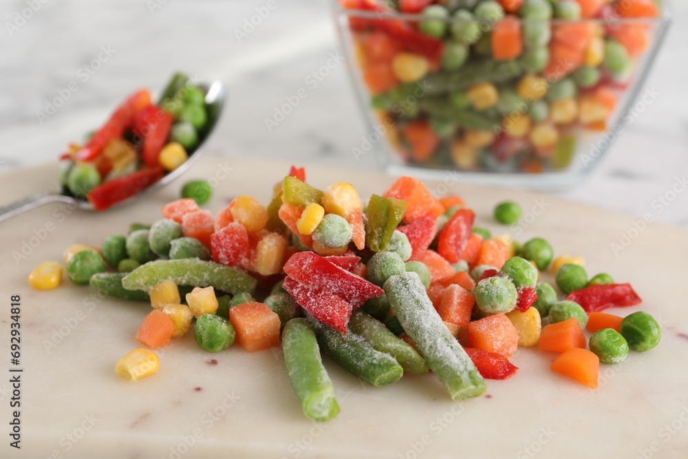 Mix of different frozen vegetables on white marble table, closeup Mix of different frozen vegetables on white marble table, closeup