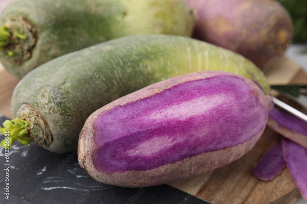 Purple and green daikon radishes on board, closeup Purple and green daikon radishes on board, closeup
