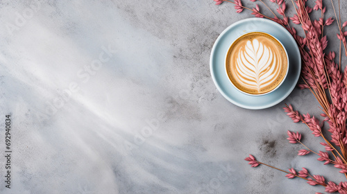 Light blue cup of cappuccino from above with latte art, dried pink leaves and grasses, on a slate stone, coffee beans, isolated on a white background.