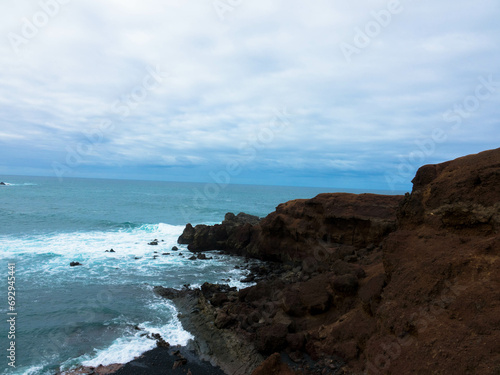 Panoramic view of Playa El Golfo volcanic beach and rocky coast on a windy day. Seen from the Charco de los Clicos viewpoint. Lanzarote, Canary Islands, Spain